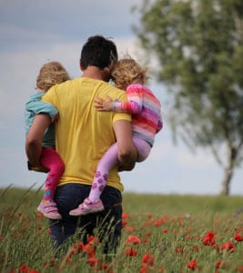 Foto en un campo de flores de un padre con sus hijos por Juliane Liebermann en Unsplash