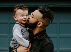 Imagen del padre besando a un niño en la mejilla
